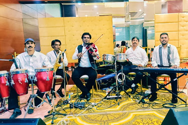 Live band performers playing violin, keyboard, saxophone, and conga drums on a stage. Musical Team 