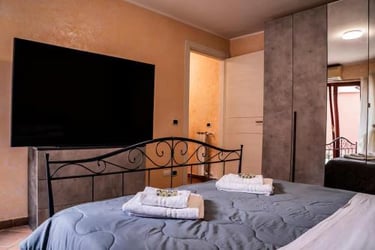 Camera matrimoniale del trilocale con TV e armadio, ideale per famiglie