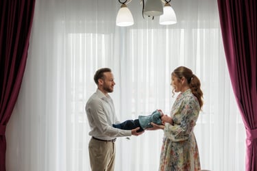 Fotograf botez Oradea – portret de familie cu bebeluș în studio, părinți tineri surprinși într-un mo