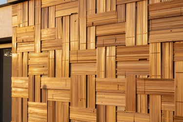 Seamless interlocking bamboo cladding installed on an exterior villa wall, golden hour sunlight