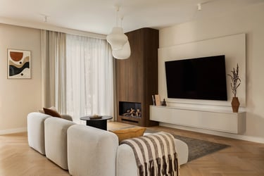 Salon Japandi: beżowa sofa modułowa, ściana TV i drewniany kominek.
