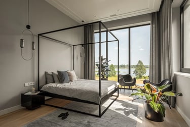 Nowoczesna sypialnia master, czarne metalowe łóżko z baldachimem i panoramiczny widok na rzekę.