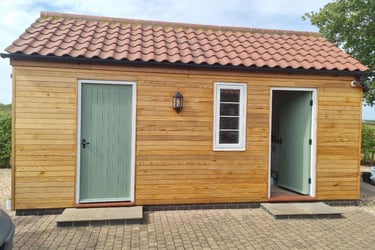 Exterior of a single storey building, with the front covered in wooden panelling.