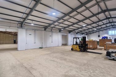 A large hall room in a warehouse, with freshly white painted walls.