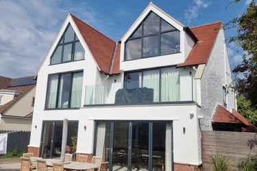 Exterior front of a painted-white, 3-storey residential home, with black-detailed windows/doors.