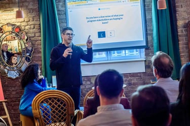 A man leading a corporate workshop presentation about program stakeholders to a seated audience.