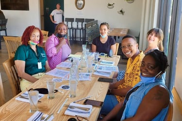 Group of people sitting around a table smiling at the camera