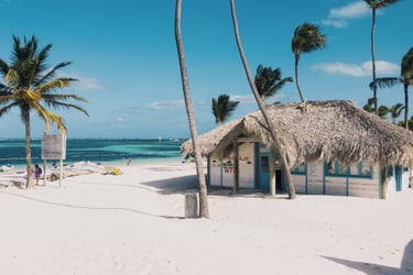Beach hut on white sand with palm trees and turquoise water in Punta Cana, Dominican Republic