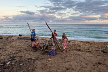 Kids building a fort on the beach in Kauai