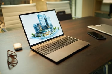a laptop showing a 3D model of a new real estate development project