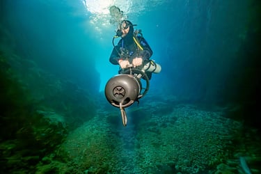 Solo diver, self relient, exploring a valley with a DPV
