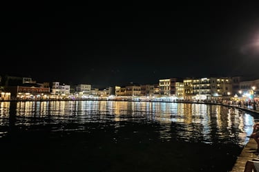 a man sitting on a bench next to a body of water