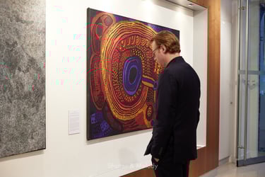Ein Mann betrachtet eine Ausstellung von Kunstwerken der Ureinwohner in der australischen Botschaft