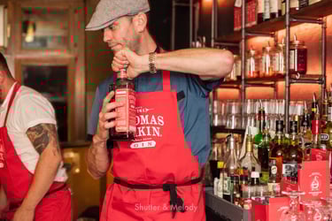 Thomas Dakin öffnet stellvertretend eine Flasche Gin.