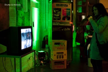 Eine Frau schaut auf einen Fernsehbildschirm in der Lobby des English Theatre Berlin.
