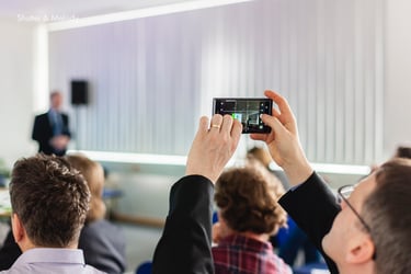 Ein Konferenzteilnehmer nimmt ein Video auf.