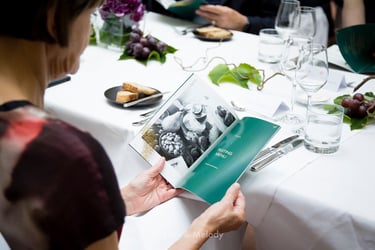 Ein Gast sieht sich beim Abendessen eine Broschüre über australische Weine an.