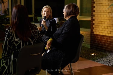 Host addressing two speakers at an event at the Australian Embassy in Berlin.