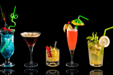 a variety of drinks in a row of glasses