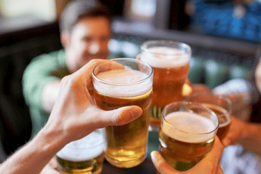 a group of people are toasting with beer