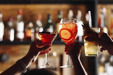 a couple of people holding glasses with drinks