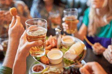 a group of people eating food and drinking