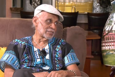 Clive Nunez actor in living room speaking on set of Legacies – The Series. Caribbean television scen