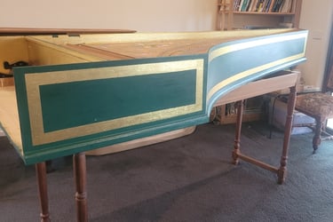 a harpsichord case sitting on top of a carpet