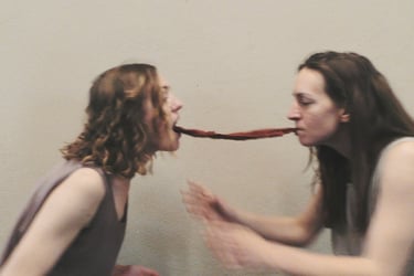 Two dancers connected by a red scarf between their mouths – film still from Being Together by Tina Bikic