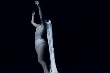 Film still from “Der Schatten” by Tina Bikic showing a dancer in motion, wearing a white mask and costume.