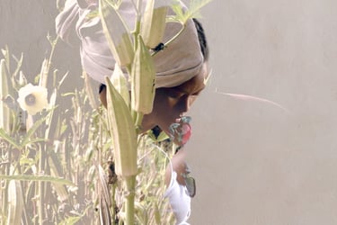 Close-up of a performer standing in tall grass – La distanza di sicurezza by Tina Bikic