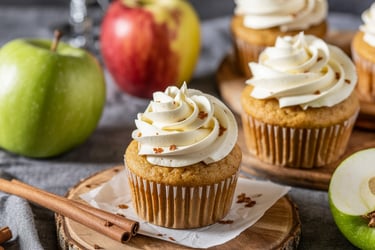a cupcake with cream frosting and apples