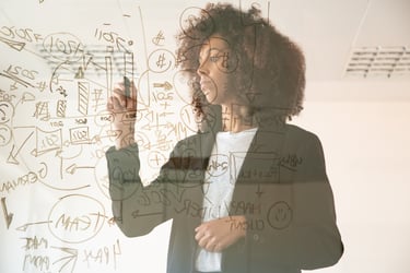 Business woman drawing strategic financial diagrams and data charts on a glass wall.