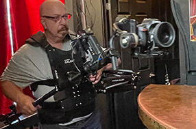a man using a Steady-cam gimbal rig with a 4k camera