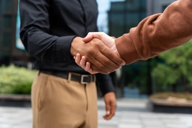 a man and woman shaking hands in front of a building