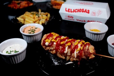 a corndog on a plate with ketchup and ketchup