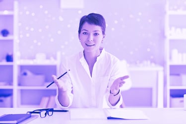 a woman in a white shirt and glasses sitting at a desk