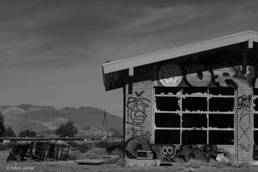 black and white abandoned auto garage with graffiti and mountains in baker california