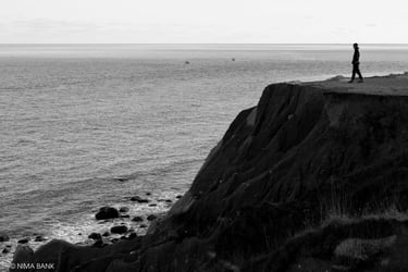 a person standing on a cliff overlooking the ocean