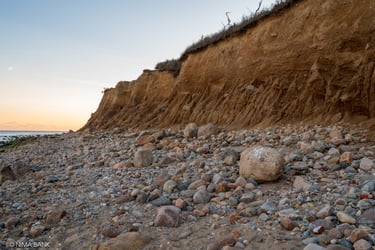 rocks and boulders with bluffs in the background in montauk point ny