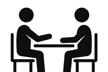 Black icon of two people sitting at a table for a job interview or business consultation.