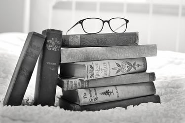 A stack of books with glasses on top of them representing educational translations