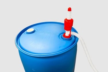 Manual red and white siphon pump attached to a 55-gallon blue plastic water storage drum.