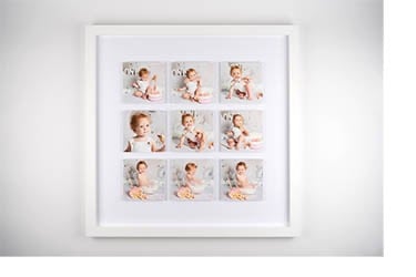 A square white picture frame displaying a nine-photo collage of a baby's first birthday cake smash.