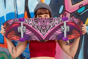 a woman holding a skateboard in front of a graffiti - covered wall