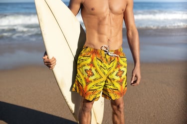 a man in a yellow swimsuit holding a surfboard