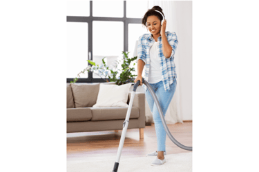 A woman vacuums while listening to an audiobook