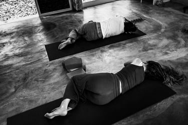Yoga students lie on their right side as part of a relaxation practice