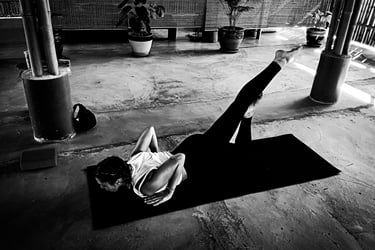 A woman practising a variant of Locust Pose a during yoga class