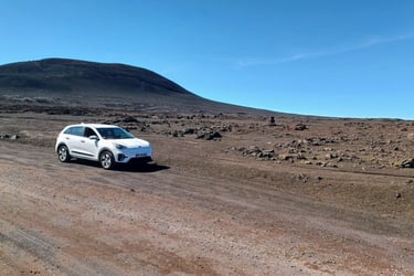 a white suv driving down a dirt road